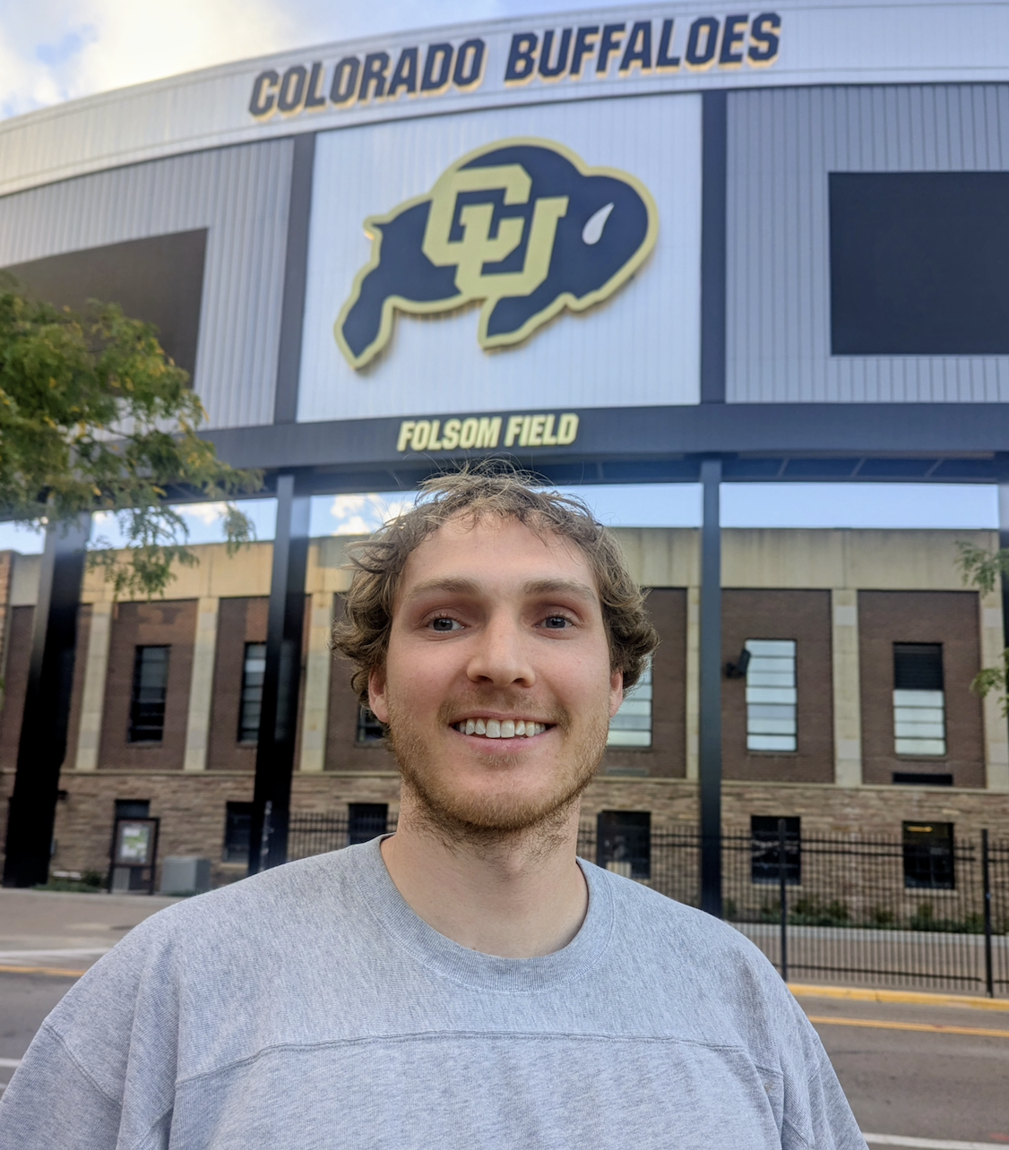Portrait of me standing in front of the University of Colorado football stadium